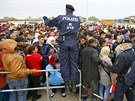 Rakoutí policisté se snaí zklidnit dav migrant u msta Nickelsdorf nedaleko...