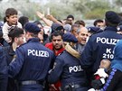 Rakoutí policisté se snaí zklidnit dav migrant u msta Nickelsdorf nedaleko...