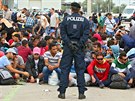 Rakoutí policisté stojí u skupiny migrant, kteí práv peli hranici s...