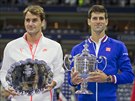 VÍTZ A PORAENÝ. Novak Djokovi (vpravo) s pohárem pro vítze US Open pózuje...