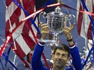 OSLAVA VÍTZE. Novak Djokovi s pohárem pro vítze tenisového US Open v záplav...