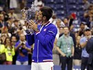 Srbský tenista Novak Djokovi líbá pohár pro vítze US Open.