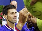 PODPISY FANOUKM. Novak Djokovi se po triumfu na US Open podepisuje fanoukm.