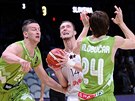 Lotyský basketbalista Kaspars Berzin se snaí vystelit na ko v obleení...