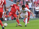 Thiago z Bayernu Mnichov (vlevo) a Koo Ja-cheol z Ausburgu svádí souboj o balón.
