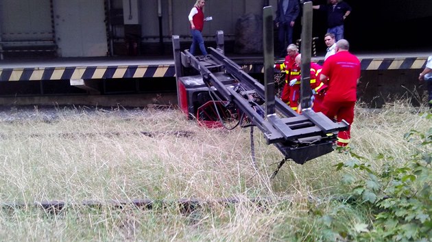 Vysokozdvižný vozík se zřítil z nákladové rampy do kolejiště a zraněný řidič pod ním zůstal přimáčknutý.