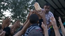 Rozdávání jídla mezi uprchlíky na srbsko-maarské hranici (16. záí 2015)
