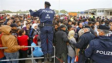 Rakoutí policisté se snaí zklidnit dav migrant u msta Nickelsdorf nedaleko...