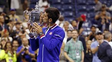 Srbský tenista Novak Djokovi líbá pohár pro vítze US Open.
