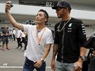 Japonský fanouek si poizuje selfie s Lewisem Hamiltonem.