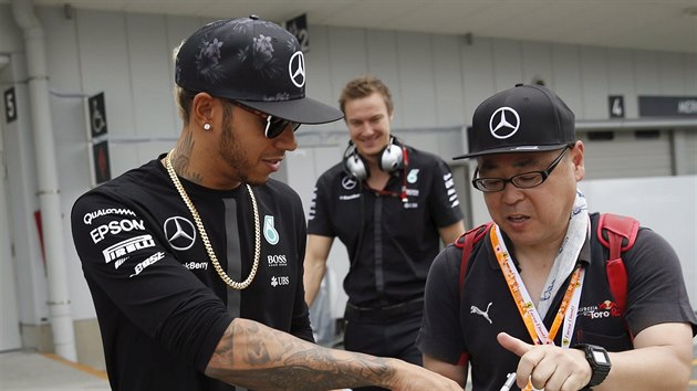 Lewis Hamilton (vlevo) dv autogram japonskmu fanoukovi.