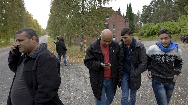 Migranti se prochz kolem uprchlick ubytovny ve finskm mst Lahti.