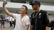 Japonský fanouek si poizuje selfie s Lewisem Hamiltonem.