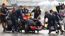 Daniil Kvjat sedí ve voze red bull, obklopují ho technici a mechanici.