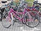 Růžové kolo září mezi ostatními bicykly u stojanu před budovou Jihočeské...
