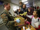 Nmecký voják rozdává na berlínském vlakovém nádraí jídlo uprchlíkm, kteí...