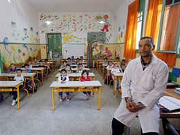Schoolchildren listen to a teacher as they study during a class in the Oudaya...