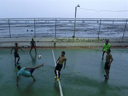 FOTBAL V GHETTU. Panamtí chlapci hrají fotbal bhem detivého poasí v Casco...