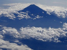 OSAMLA HORA. Japonská hora Fudi v obklopení mrak pohledem z letadla. Fudi...
