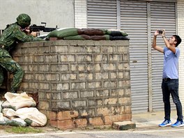 SPORNÝ TCHAJ-WAN. Reportér poizuje snímky vojáka bhem vojenského cviení v...