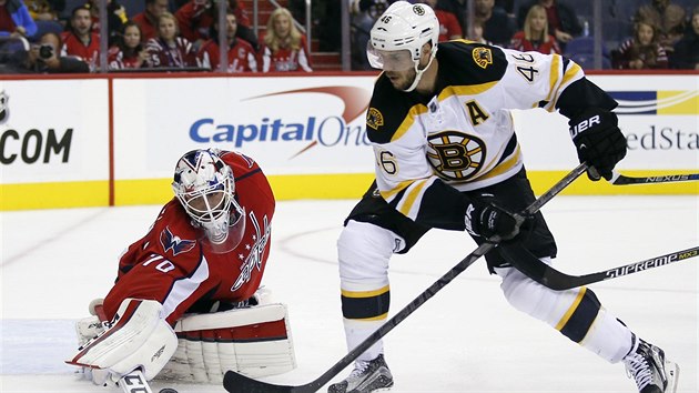 Washingtonsk brank Braden Holtby el anci Davida Krejho z Bostonu.