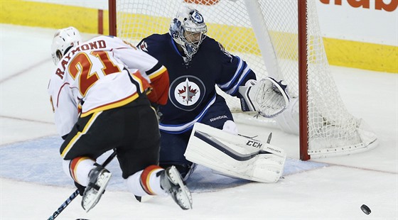 Branká Winnipegu Ondej Pavelec elí nájezdu Masona Raymonda z Calgary.