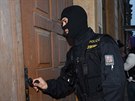 Maskovaní policisté picházejí do domu v centru msta Olomouce, který patí...
