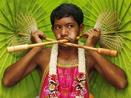 A devotee of the Chinese Bang Neow shrine with umbrellas pierced in his cheeks...