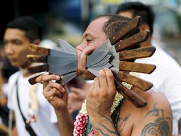 A devotee of the Chinese Samkong Shrine walks with knives pierced through his...