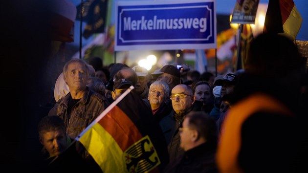 Demonstranti z hnutí Pegida nesou nápis „Merkelová musí pryč“ na shromáždění hnutí v Drážďanech. (12. října 2015)