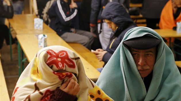 Uprchlíci se zahřívají při čekání na registraci v úřadu pro zdravotní a sociální záležitosti v Berlíně. (14. října 2015).