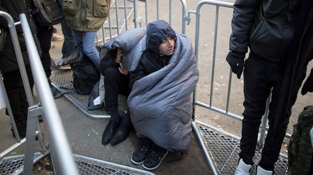 Uprchlíci se v Berlíně během čekání na registraci snaží zahřát. Teplota vzduchu se totiž již přiblížila k bodu mrazu. (12. 10. 2015)