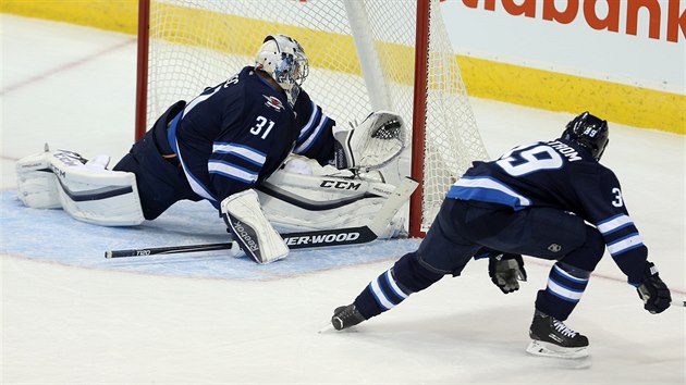 Ondej Pavelec (31) z Winnipegu zasahuje v utkání se St. Louis, sleduje ho...