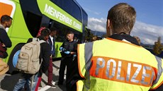Nmetí policisté provádjí pasovou kontrolu v autobusech, které projídjí po...