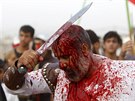 Iraq Shi'ite Muslim men bleed as they gash their foreheads with swords and beat...