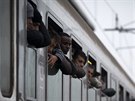 Uprchlíci vyhlíejí z vlaku, který je pevezl z Chorvatska do Slovinska (28....