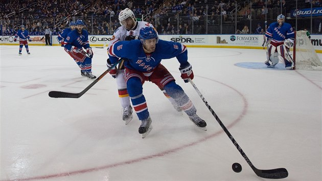 Michael Frolk z Calgary atakuje v obrannm psmu New York Rangers soupee Dana Girardiho.