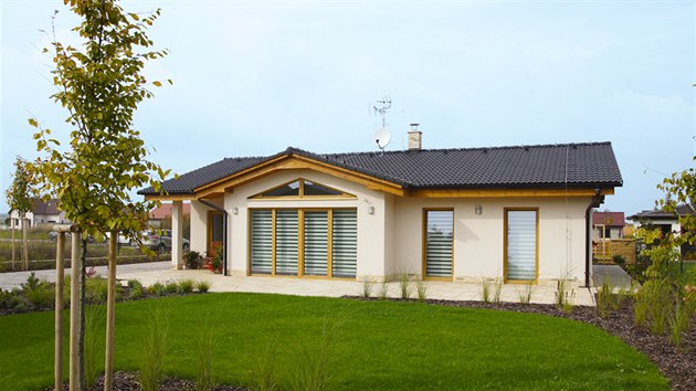 Dům jednoduchého obdélníkového tvaru s nízkou sedlovou střechou a proskleným rizalitem považují majitelé domu za optimální kompromis mezi starší zástavbou a moderní architekturou.