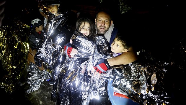 Syrt uprchlci zahvaj sv dti pot, co je zachrnili et rybi a dovezli na Lesbos (20. jna 2015).
