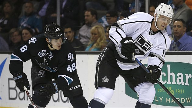 Brayden McNabb (vpravo) z Los Angeles odehrv puk ped Tomem Hertlem ze San Jose.