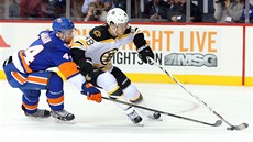 Calvin de Haan z NY Islanders se snaí vypíchnout puk, který má pod kontrolou...