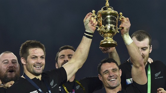 Novozélandský kapitán Richie McCaw (vlevo) a hvzda týmu Dan Carter s trofejí...