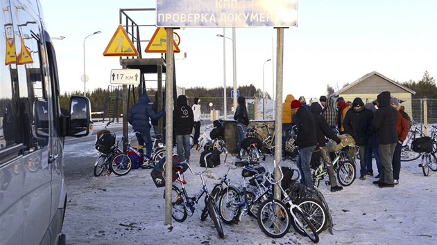 Uprchlíci překračují na kolech rusko-norskou hranici (31. října 2015).