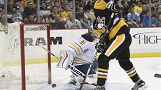 Ben Lovejoy z Pittsburghu pekonává brankáe Buffala Chada Johnsona.