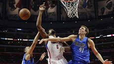 DeAndre Jordan z Los Angeles Clippers bojuje mezi dvojicí hrá Dallasu Dirkem...