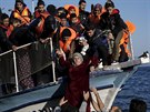 Migranti pomáhají en z lodi po piplutí na ecký Lesbos (7. listopad 2015)