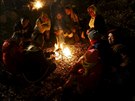 Uprchlíci se na slovinsko-rakouských hranicich zahívají u ohn (3. listopadu...