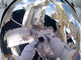 Helma kosmonauta Mika Fossuma odráí panoramatickou scénu se zakotveným...