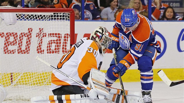 Ryan Nugent-Hopkins z Edmontonu se sna dotlait puk za branke Michala Neuvirtha z Philadelphie.