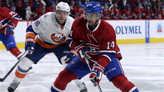 Tom Plekanec z Montrealu se chyst ke stelb, sleduje ho Nikolaj Kuljomin  z New York Islanders.